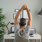 back-view-man-desk-stretching-while-working-from-home