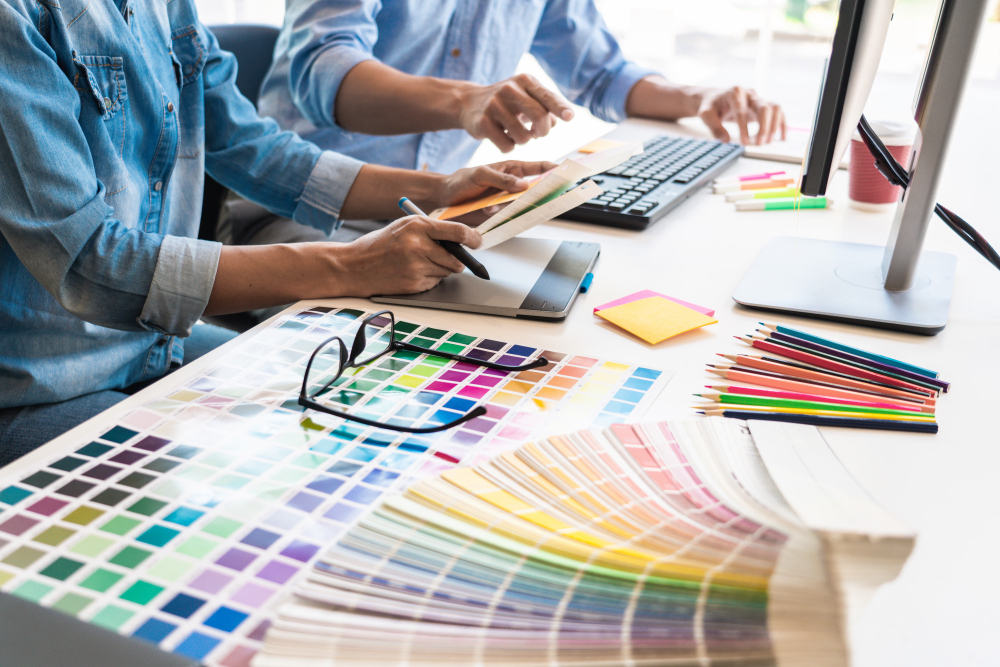 people sitting at a desk using color charts to design