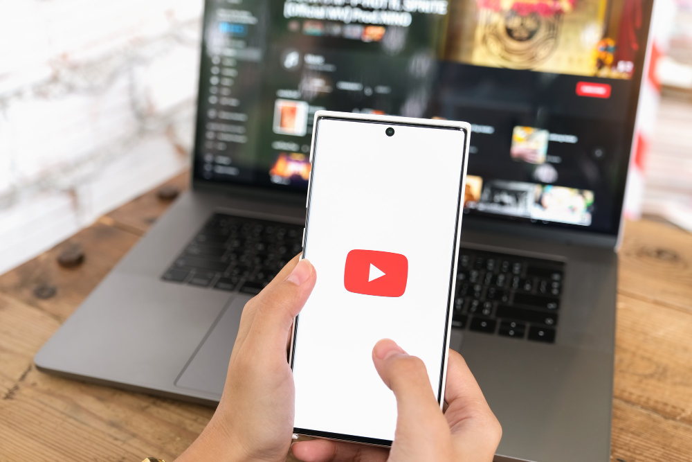 Hand holding phone with YouTube symbol