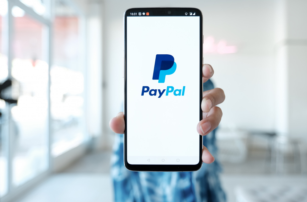 woman-hands-holding-smartphone-with-paypal-apps-screen-paypal-is-online-electronic-payment-system