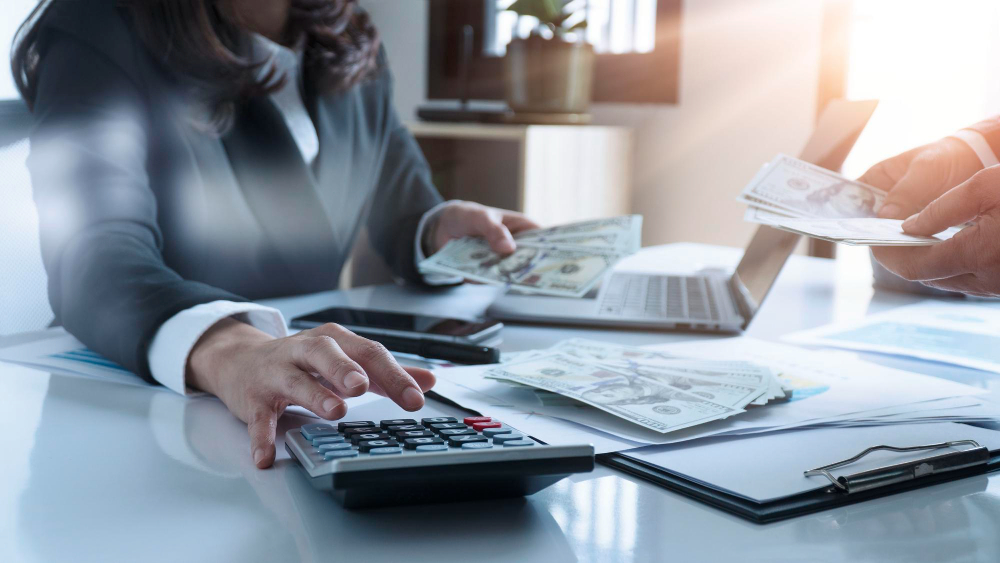 Woman using calculator to determine marketing budget